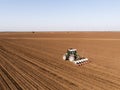Aerial shot of a farmer seeding, sowing crops at field. Royalty Free Stock Photo