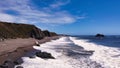 Aerial shot of foamy waves crashing the Goat Rock beach of Jenner in California, USA