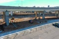 A aerial shot of a freeway with cars and semi trucks driving on the highway with construction workers working underneath