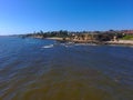 An aerial shot of a gorgeous summer landscape at the beach with blue ocean water and waves crashing into the large rocks Royalty Free Stock Photo