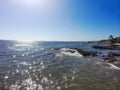 An aerial shot of a gorgeous summer landscape at the beach with blue ocean water and waves crashing into the large rocks Royalty Free Stock Photo