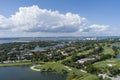 Aerial shot of a gorgeous summer landscape at Miami Beach Golf Club with lush green grass and trees, blue ocean water, homes