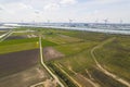 aerial shot of green fields, windmills and a river in the background, sunny day, Botlek, Netherlands