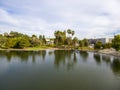 Aerial shot of the green lake, lush green trees, grass and plants at Lincoln Park with blue sky with clouds at sunset