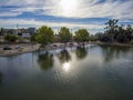 Aerial shot of the green lake, lush green trees, grass and plants at Lincoln Park with a water fountain in the center of the lake