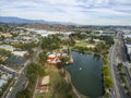 Aerial shot of the green lake, lush green trees, grass and plants at Lincoln Park with railroad tracks and cars driving