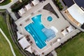 Aerial shot of green lawn, swimming pool, lounge area near beautiful mansion in the courtyard. Royalty Free Stock Photo