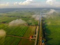 Aerial shot of green paddy field. Clouds and blue sky background.