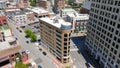 Aerial shot of the Historic One Central Plaza Building surrounded by buildings, cars on the street and lush green trees