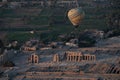 Aerial shot of a hot air balloon flying over the Valley of Kings in Egypt with historic buildings Royalty Free Stock Photo