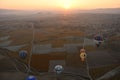 Aerial shot of hot air balloons landing in Cappadocia, Turkey at sunrise