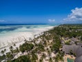 Aerial shot of houses by the palm trees on the beach by the ocean captured in Zanzibar, Africa Royalty Free Stock Photo