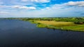 Aerial shot of Lake Tjeukermeer in the Netherlands with a field in the background on a sunny day Royalty Free Stock Photo