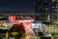 aerial shot of the Los Angeles Convention Center at sunset with cars driving on the freeway, office buildings in the city skyline