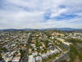 Aerial shot of the lush green trees, grass and plants at Lincoln Park with homes, apartments and mountain ranges and cars driving