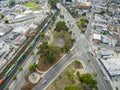 Aerial shot of the lush green trees, grass and plants at Lincoln Park with a train on the railroad tracks and cars and trucks