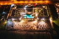 Aerial shot of a luxurious swimming pool illuminated at night, surrounded by lush greenery Royalty Free Stock Photo