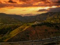 An aerial shot of the majestic mountain ranges with homes along the coastline of California, freeways with cars and powerful cloud