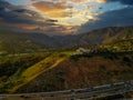 An aerial shot of the majestic mountain ranges with homes along the coastline of California, freeways with cars and powerful cloud