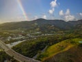 An aerial shot of the majestic mountain ranges with homes along the coastline of California, freeways with cars and powerful cloud