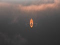 Aerial shot of man rowing a boat. Clouds reflecting on lake surface.