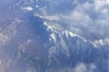 Aerial shot of mountain ranges with thin clouds covering some parts of it