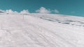 Aerial shot of mountain sidehill covered in snow and tracks