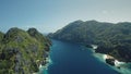 Aerial shot of mountains islands with boats, yachts at ocean bay coast. Green trees on cliff