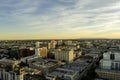 aerial shot of office buildings and apartments in the city skyline, cars driving on the street lined with lush green trees