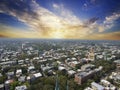 Aerial shot of the office buildings, apartments and shops in the city skyline surrounded by lush green trees, roads and cars on