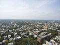 Aerial shot of the office buildings, apartments and shops in the city skyline surrounded by lush green trees, roads and cars on