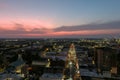 Aerial shot of office buildings and tower cranes in the city skyline with lights and cars driving along the street at sunset Royalty Free Stock Photo