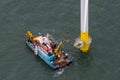 Aerial shot of an offshore wind turbine being repaired in the English Channel