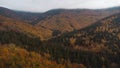 Aerial shot of orange-red and green forests at sunset in Slovak forests. Autumn fairy tale. Variety and colourfulness of nature Royalty Free Stock Photo