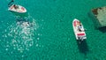 Aerial shot of people driving motorboats on a transparent sea