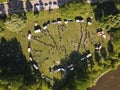 Aerial shot of people and parked cars circled in a field