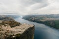 Aerial shot of the Preikestolen rocky cliff overlooking a tranquil fjord in Norway.