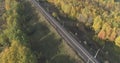 Aerial shot of railroad between autumn trees in forest in october Royalty Free Stock Photo