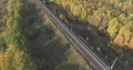 Aerial shot of railroad between autumn trees in forest in october Royalty Free Stock Photo