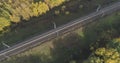 Aerial shot of railroad between autumn trees in forest in october Royalty Free Stock Photo