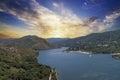 aerial shot of the rippling blue waters of Silverwood Lake with a beach, mountains covered in lush green trees, plants and grass Royalty Free Stock Photo