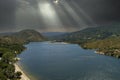 aerial shot of the rippling blue waters of Silverwood Lake with a beach, mountains covered in lush green trees, plants and grass Royalty Free Stock Photo