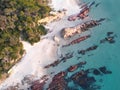 Aerial shot of rocks on the sandy beach with crystal clear water in Merimbula, Australia. Royalty Free Stock Photo