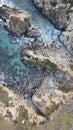 Aerial shot of a rocky shoreline with pounding waves crashing against the large rocks. Royalty Free Stock Photo