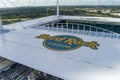 an aerial shot of the roof of Hard Rock Stadium surrounded by homes, office buildings and lush green trees and grass in Miami