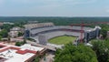 aerial shot of Sanford Stadium surrounded by buildings, a tower crane and lush green trees with blue sky and clouds in Athens Royalty Free Stock Photo