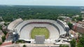 aerial shot of Sanford Stadium surrounded by buildings, a tower crane and lush green trees with blue sky and clouds in Athens Royalty Free Stock Photo