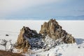 Aerial shot of Shamanka rock on Olkhon island in winter. Frozen lake Baikal in daylight, Siberia, Russia. Drone flies above Royalty Free Stock Photo