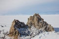 Aerial shot of Shamanka rock on Olkhon island in winter. Frozen lake Baikal in daylight, Siberia, Russia. Drone flies above Royalty Free Stock Photo