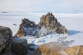 Aerial shot of Shamanka rock on Olkhon island in winter. Frozen lake Baikal in daylight, Siberia, Russia. Drone flies above Royalty Free Stock Photo